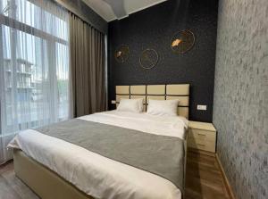 a bedroom with a large bed and a large window at Days Hotel in Yerevan