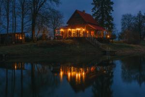 a house on the shore of a lake at night at Brīvdienu māja Straumēni in Pāle