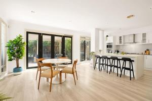 a kitchen and dining room with a table and chairs at Deluxe Family Montpellier Gardens Estate - Burwood in Burwood