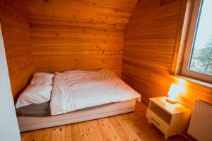 a small bedroom with a bed in a wooden room at Brīvdienu māja Straumēni in Pāle