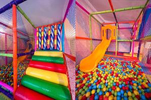 a colorful play room with a slide and balls at Хижа Марциганица in Asenovgrad