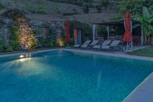 una gran piscina con sillas y sombrillas en Villa Marlia 10, en Lucca