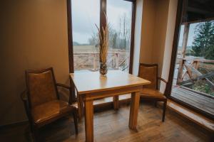 a table and chairs in a room with a window at Brīvdienu māja Straumēni in Pāle