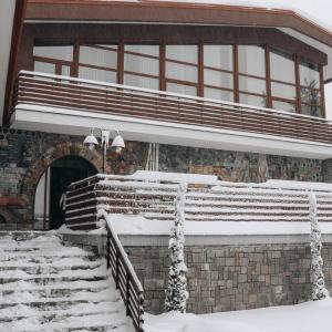 a building with snow covered steps and a building with a window at Hizha Martsiganitsa in Asenovgrad