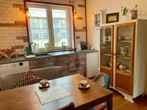 a kitchen with a wooden table and a dining room at Apartament Do Zobaczenia Olsztyn in Olsztyn