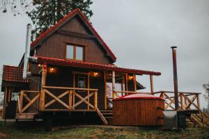 a log cabin with a hot tub in front of it at Brīvdienu māja Straumēni in Pāle