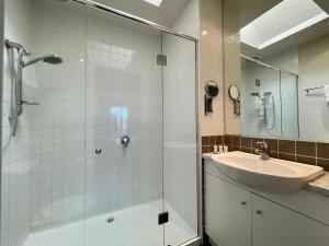 a bathroom with a sink and a glass shower at Amazing Beachfront & City Views 2 bed 2 bathroom in Melbourne +24 photos
