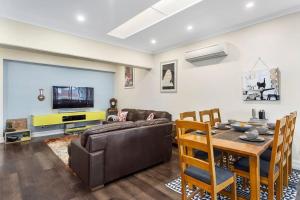 a living room with a couch and a table at Heritage Building Penthouse CBD Apartment in Hobart