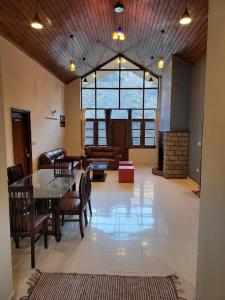 a large living room with a table and chairs at Oski Inn in Manāli