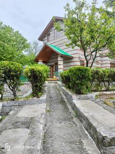 a house with a stone path in front of it at Oski Inn in Manāli