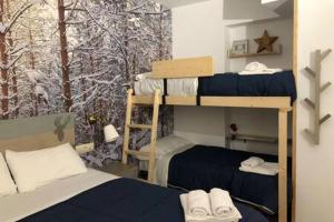 a bedroom with two bunk beds and a snow covered window at Apartament el Cérvol in La Molina