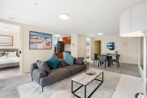 a living room with a couch and a dining room at Spacious&Cozy 2 bedroom City Point Melbourne Apt in Melbourne