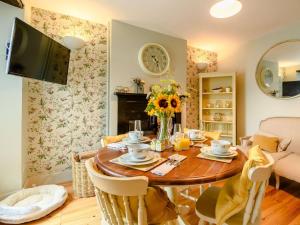 a dining room with a wooden table with flowers on it at 2 Bed in Milford Haven 88529 in Milford Haven