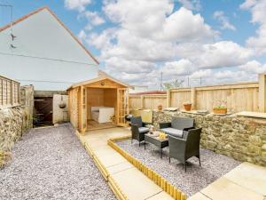 a patio with chairs and a table and a building at 2 Bed in Milford Haven 88529 in Milford Haven