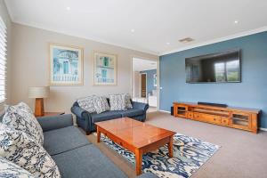 - un salon avec un canapé et une télévision dans l'établissement Expansive Family Entertainer In Blue Chip Locale, à Mount Martha
