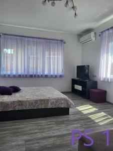 a bedroom with a bed and a flat screen tv at Purple StudioS in Veliko Tŭrnovo