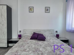 a bedroom with a large bed with purple pillows at Purple StudioS in Veliko Tŭrnovo