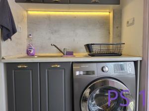 eine Küche mit einer Waschmaschine unter der Theke in der Unterkunft Purple StudioS in Weliko Tarnowo