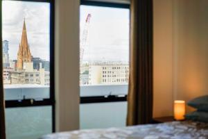 a view of a city from a bedroom window at Panoramic View CBD 1 Bed Apt +OFFICE (Collins) in Melbourne