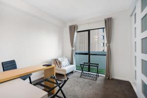 a living room with a desk and a chair at Panoramic View CBD 1 Bed Apt +OFFICE (Collins) in Melbourne