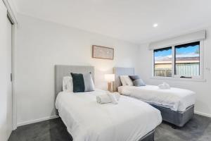 two beds in a room with two windows at Relaxed at Rosebud-Cosy 3 bedroom beach escape* in Rosebud