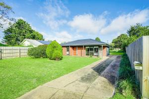 a house with a fence and a grass yard at Relaxed at Rosebud-Cosy 3 bedroom beach escape* in Rosebud