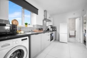 una cocina blanca con lavadora y secadora. en Brand New One Bed Cradley Heath - 4MH - Parking - Netflix - Top Rated, en Old Hill