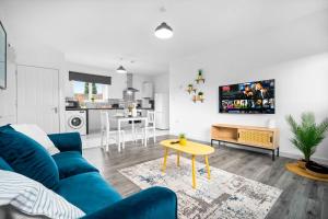 Brand New One Bed Cradley Heath - 4MH - Parking - Netflix - Top Rated في Old Hill: غرفة معيشة مع أريكة زرقاء ومطبخ