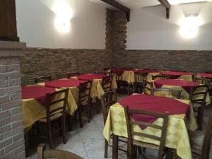 Zimmer mit Tischen und Stühlen sowie roten und gelben Tischen in der Unterkunft PALMA RESIDENCE - Dependance LE MAGNOLIE in Marco Simone