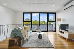 a living room with a couch and a tv at Contemporary Central Brunswick 2-Story Townhouse* in Melbourne