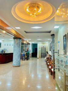 - un hall doté d'une salle d'attente avec des chaises et un lustre dans l'établissement Sao Pho Hien Hotel, à Hạ Long