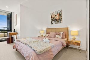 a bedroom with a large bed with two pillows at Brand New Box Hill Central Executive w pool+gym in Box Hill