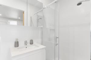 a white bathroom with a sink and a shower at Rye Getaway - Well Appointed & Cozy Family Home* in Rye +30 photos