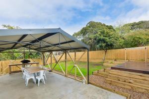 a tent with chairs and a table on a patio at Rye Getaway - Well Appointed & Cozy Family Home* in Rye