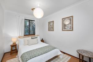 パースにあるApplecross Village Gem 2BRの白いベッドルーム(ベッド1台、窓付)