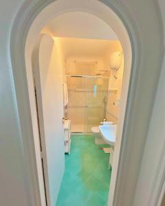 um arco que leva a uma casa de banho com WC e lavatório em Villa Azul em Anacapri