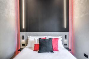 a bed with red and black pillows on it at Gallery Experience Napoli in Naples