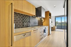 a kitchen with a sink and a stove top oven at Richmond Heritage Executive Apt for 2 w parking in Melbourne