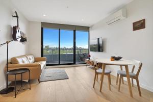 a living room with a couch and a table at Richmond Heritage Executive Apt for 2 w parking in Melbourne