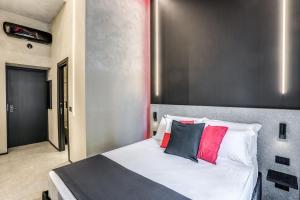 a bedroom with a bed with red and black pillows at Gallery Experience Napoli in Naples