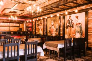 a restaurant with tables and chairs and pictures on the wall at Aynur Qala Resort in Quba