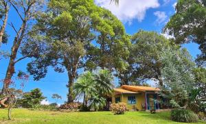 una casa amarilla en un campo con árboles en Equipped cottage in Laguna Hule en Río Cuarto