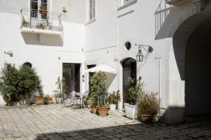 a courtyard of a white building with potted plants at Le Tre Sorelle in Bari