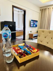 a bottle of water and a tray of food on a table at Designer's Luxe Delight-Elysium Tower in Islamabad