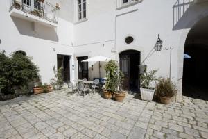 a courtyard with a table and chairs and an umbrella at Le Tre Sorelle in Bari