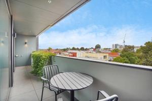 een tafel en stoelen op een balkon met uitzicht bij Luxurious Elsternwick Apt Living with Parking in Melbourne