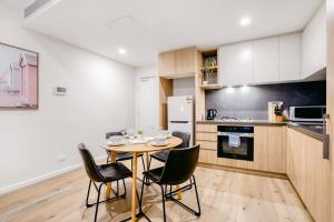 a kitchen and dining room with a table and chairs at Penny Lane - 2BR Apt in the Heart of Moonee Ponds in Melbourne +8 photos