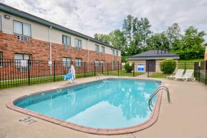 a person is walking by a swimming pool at Motel 6 - Georgetown, KY - Lexington North in Georgetown