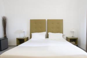 a bedroom with a large white bed with two lamps at Le Tre Sorelle in Bari
