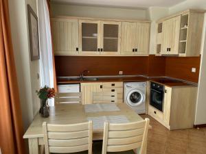 a small kitchen with a table and a washing machine at Pirin Golf private studio in Razlog +5 photos